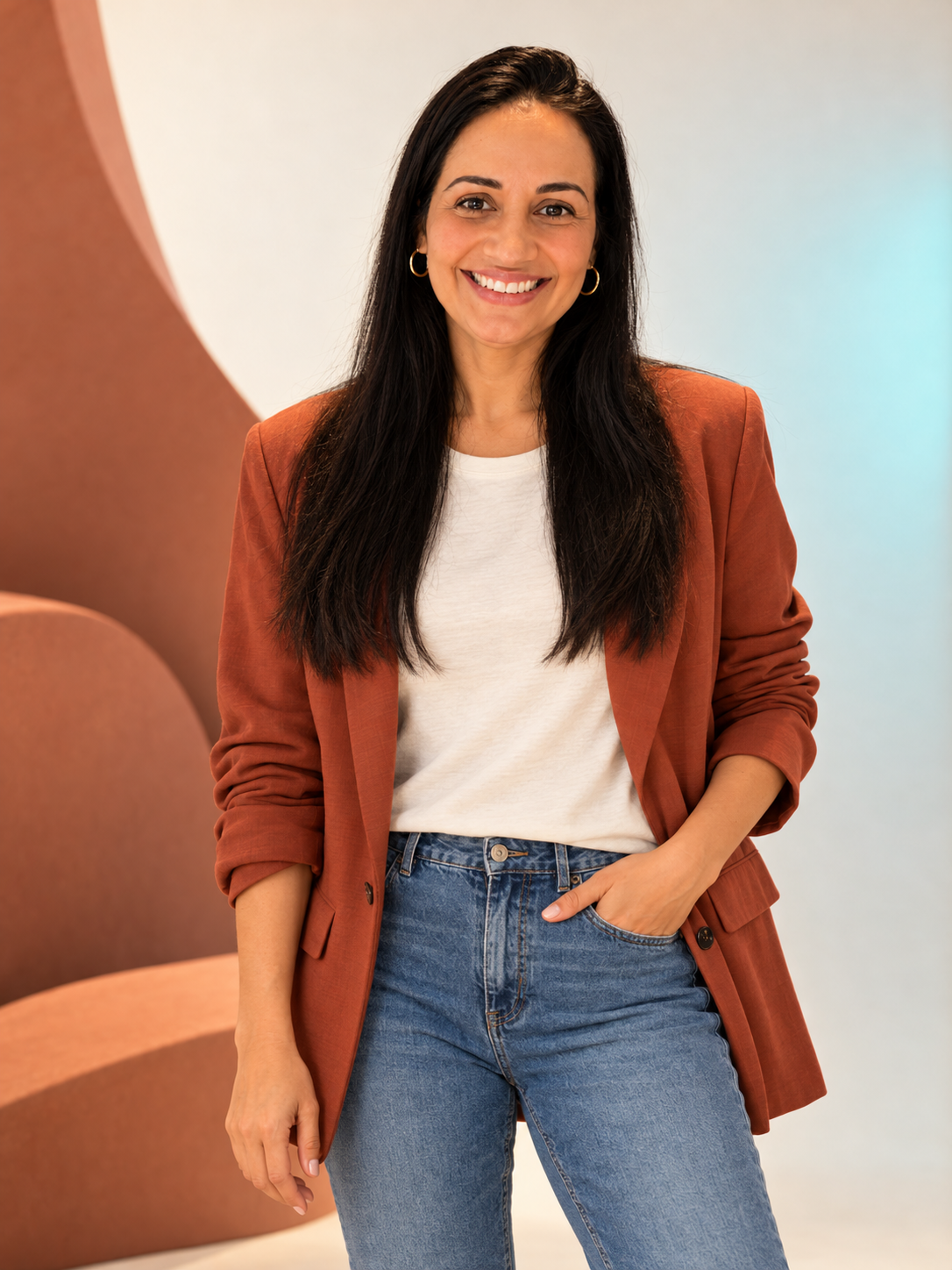 Retrato editorial da criadora da Alinnetex Digital, com blazer terracota e jeans